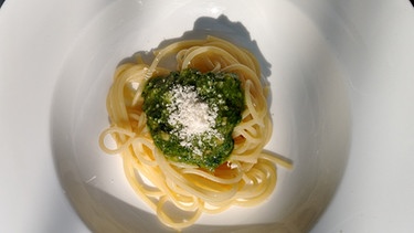 Auf eine weißen Teller ist eine Portion Spaghetti mit frischem Bärlauchpesto und Parmesan angerichtet. | Bild: BR/ Sabine Dangel